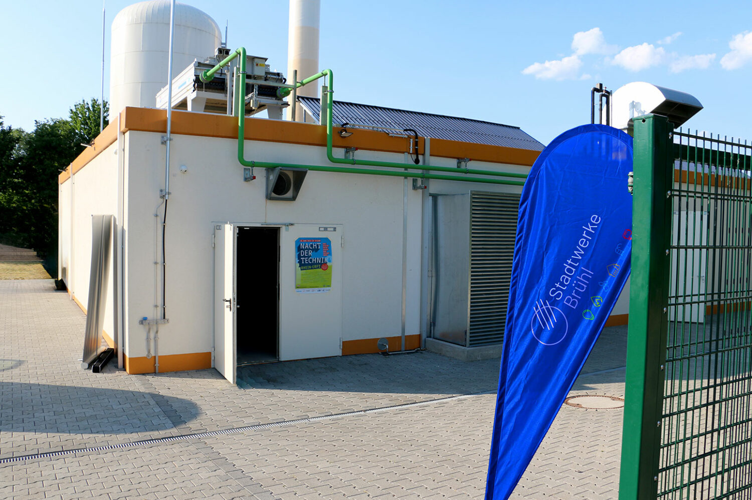 Blockheizkraftwek von außen mit Beachflag der Stadtwerke im Vordergrund