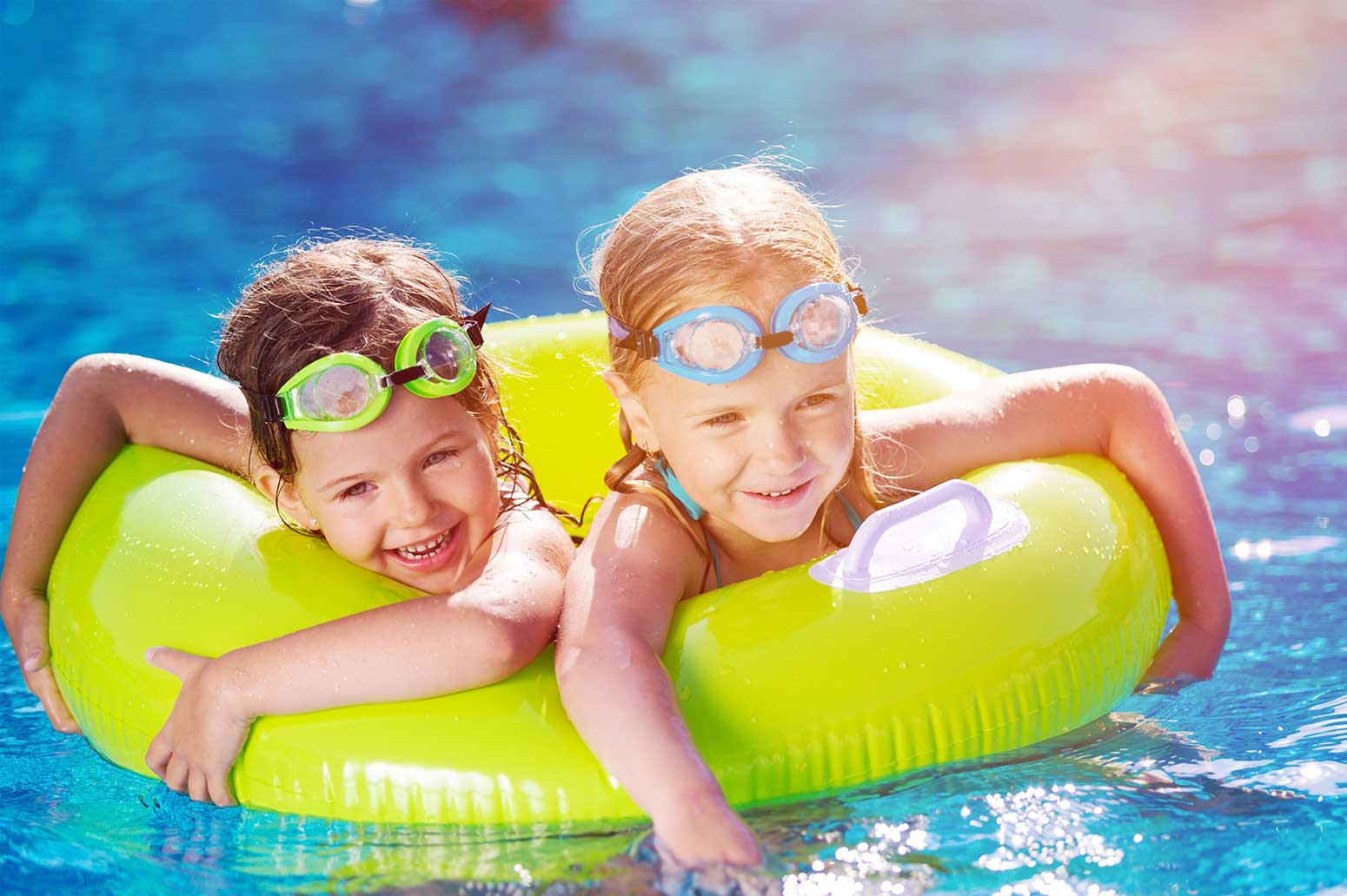 2 Kinder mit Taucherbrillen in einem Schwimmreifen