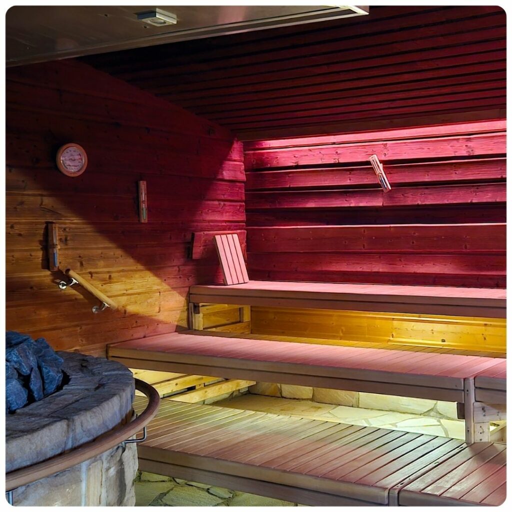 SUURI-Sauna mit Ofen im rötlichen Licht