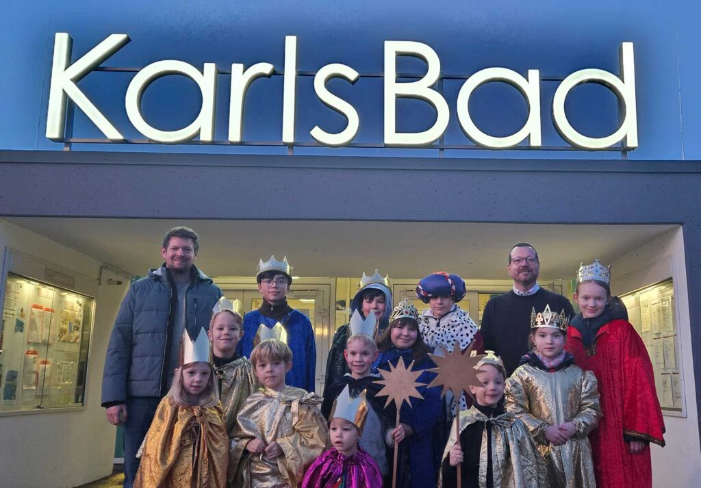 Sternsinger stehen vor dem Eingang des KarlsBad