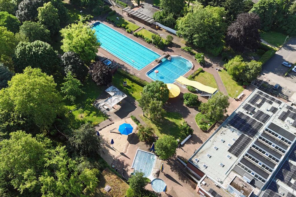 Freibad aus der Vogelperspektive mit Park, 50 Meter und Nichtschwimmerbecken