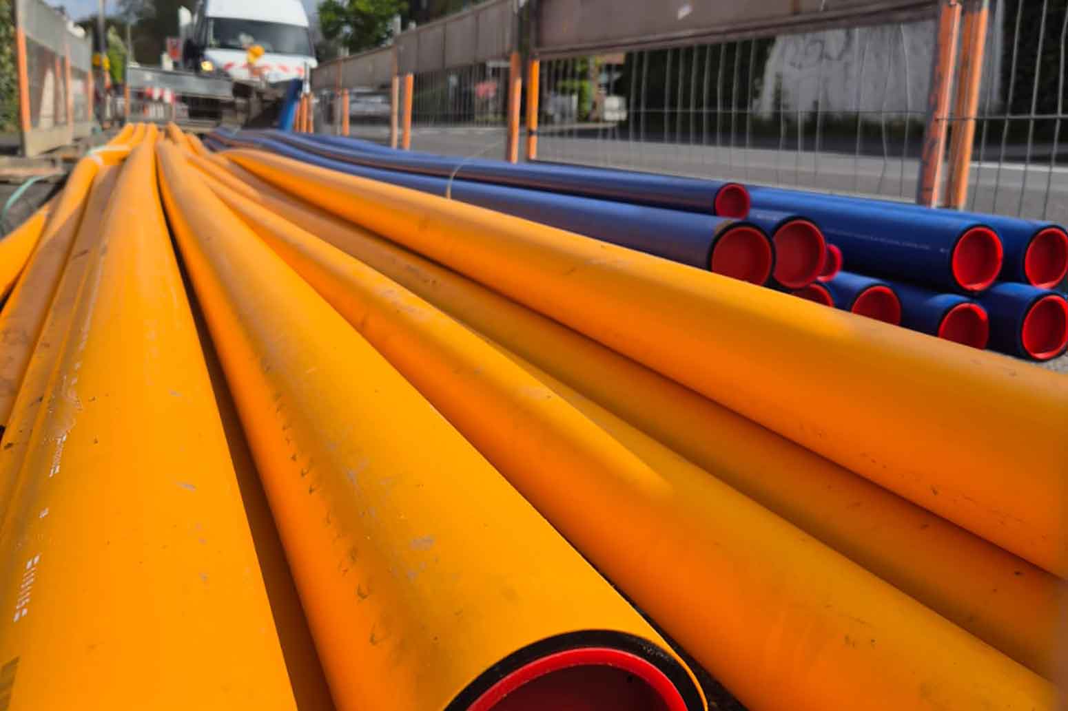 Sehr lange Rohre und Baustellenfahrzeig im Hintergrund