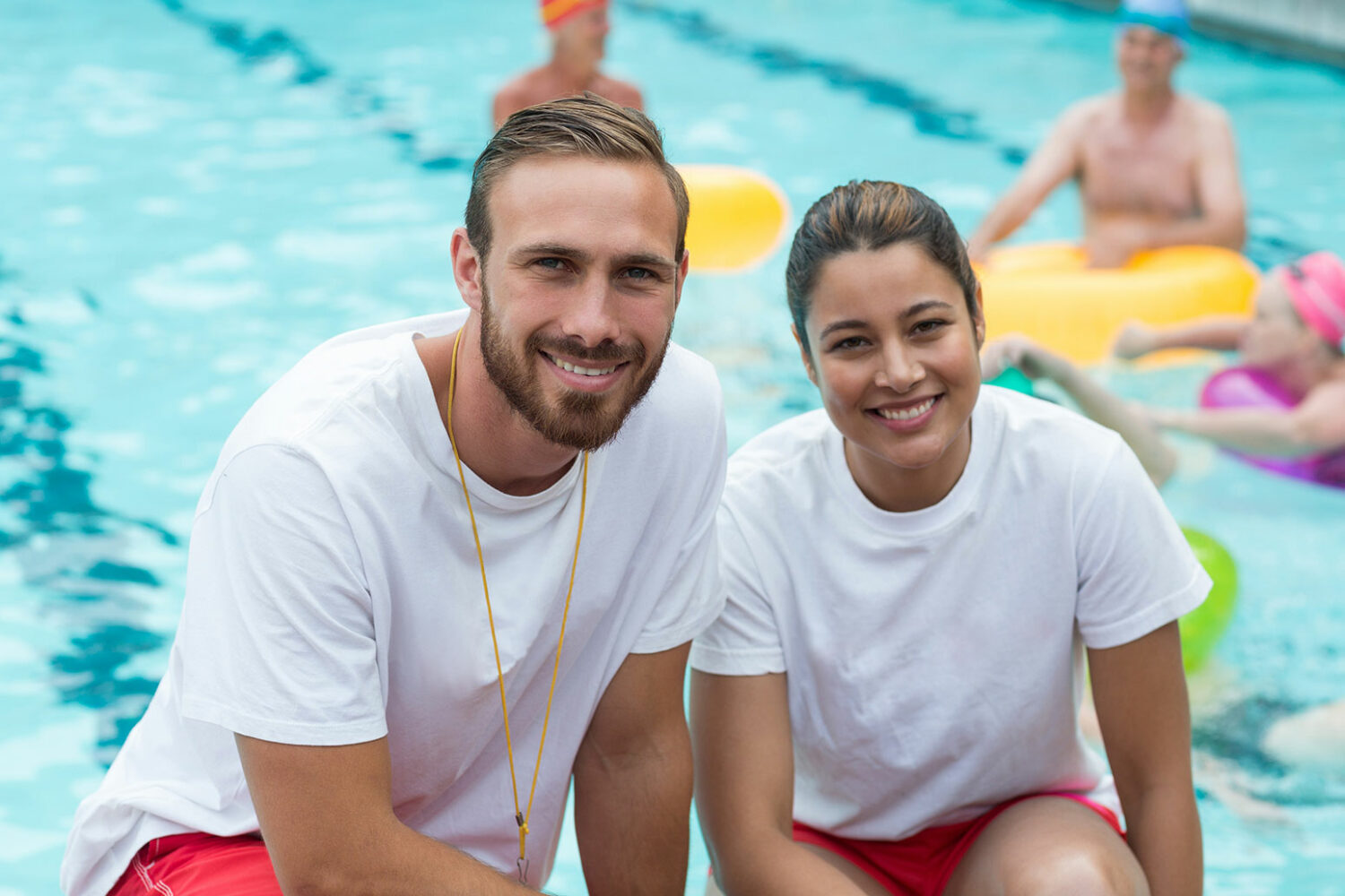 Zwei Schwimmbadmitarbeiter vor dem Freibadbecken.