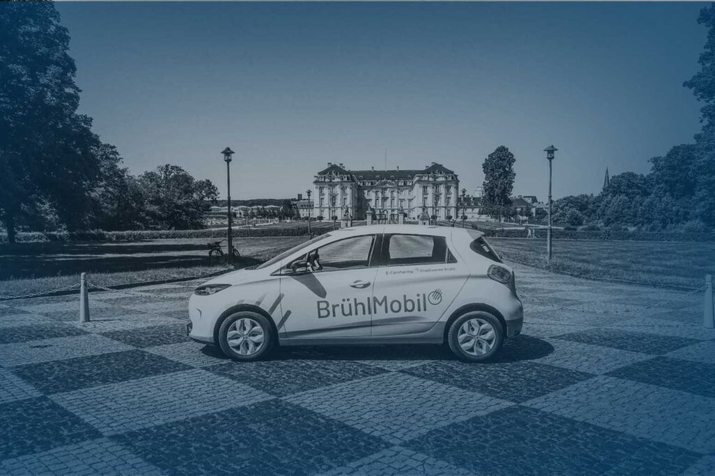 E-Carshring Auto vor dem Brühler Schloss in bedeckten Farben